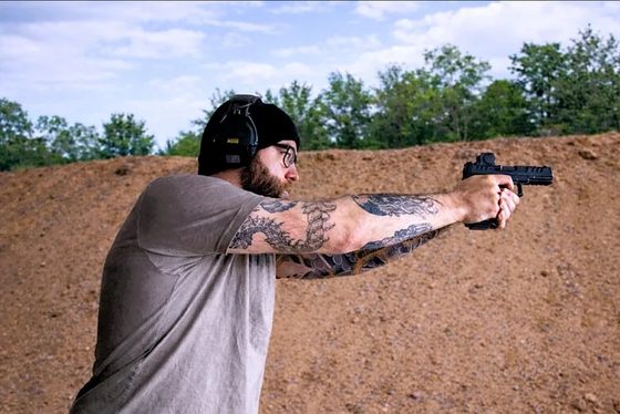 Dr. Sean Dageforde firing a pistol on a range