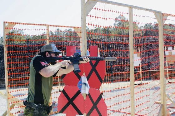 William Ring firing a rifle at a barricade